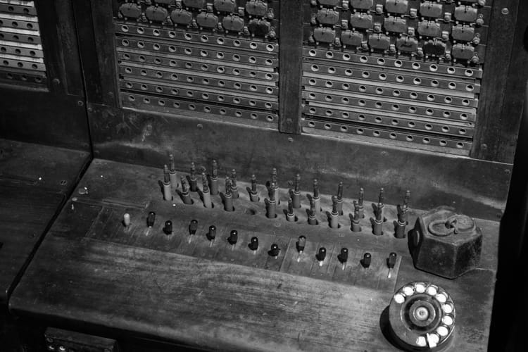 Black and white photo of an old telephone switchboard with cables and switches, symbolizing how workflows connect different systems in n8n.